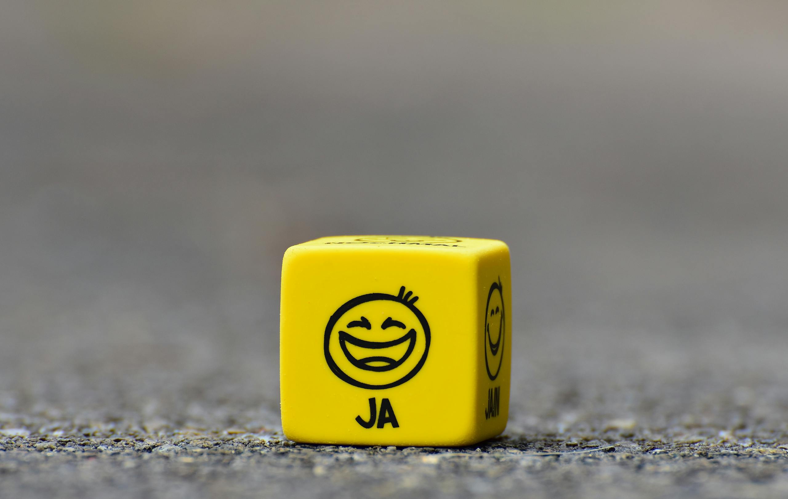Yellow Cube on Brown Pavement